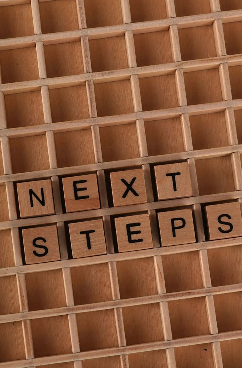 格子状に並べられた木製のキューブに「Next Steps」という言葉が表示されたモチベーションコンセプトの画像。